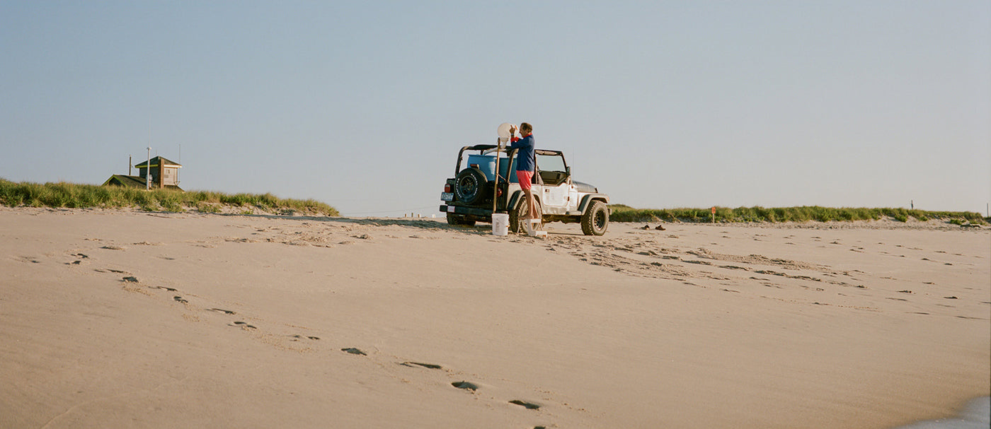Jeep on a sandy beach with a clear sky collecting Atlantic Ocean seawater